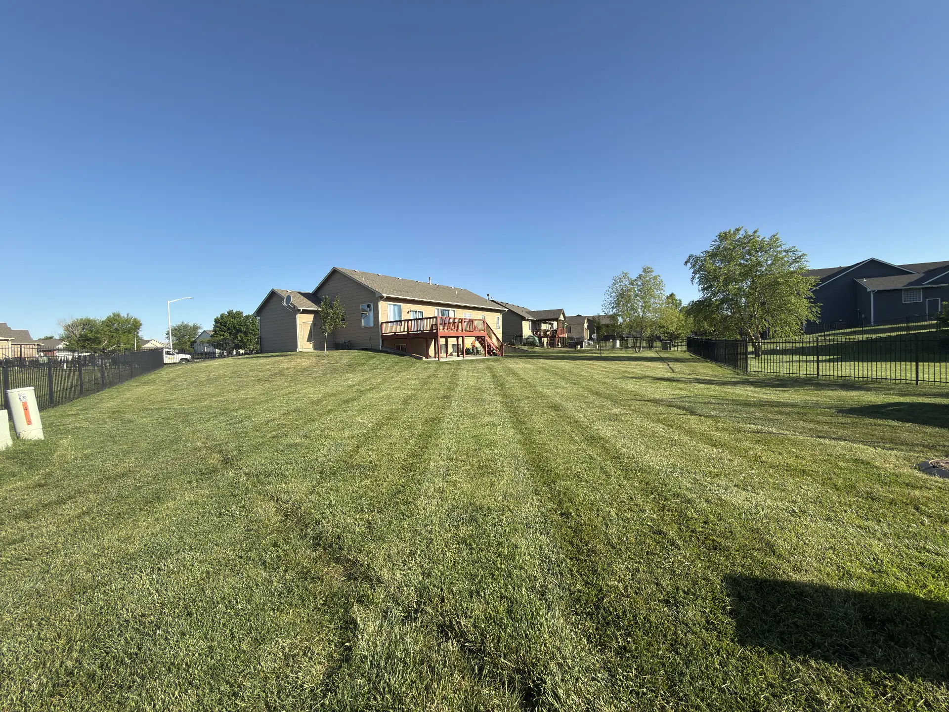 Large backyard freshly mowed with clean stripes in Wichita, Kansas